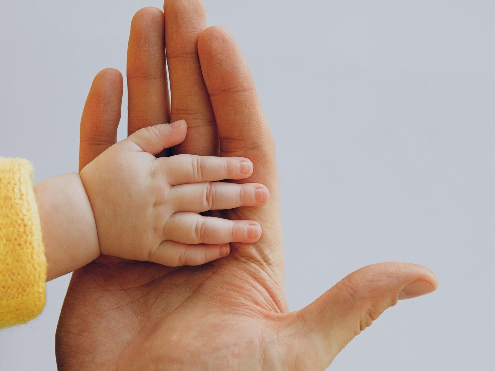 Father and baby hands together