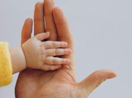 Father and baby hands together