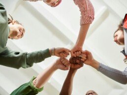 People in circle formation doing fist bump
