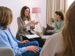 Mental female specialist speaking to group of clients